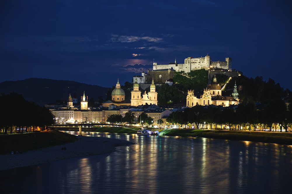 Ein Schloss wird nachts vom Wasser beleuchtet