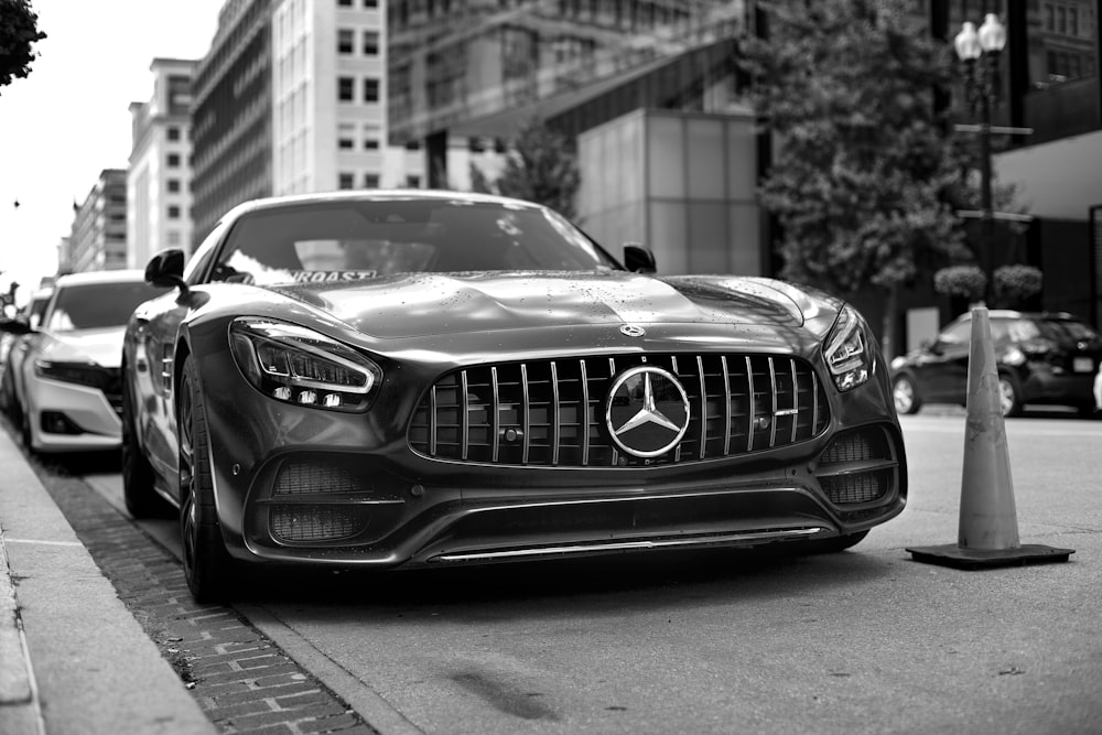 a black and white photo of a car parked on the side of the road