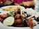 A close-up of a sizzling chorizo llanero served with fresh cilantro and lime wedges.
