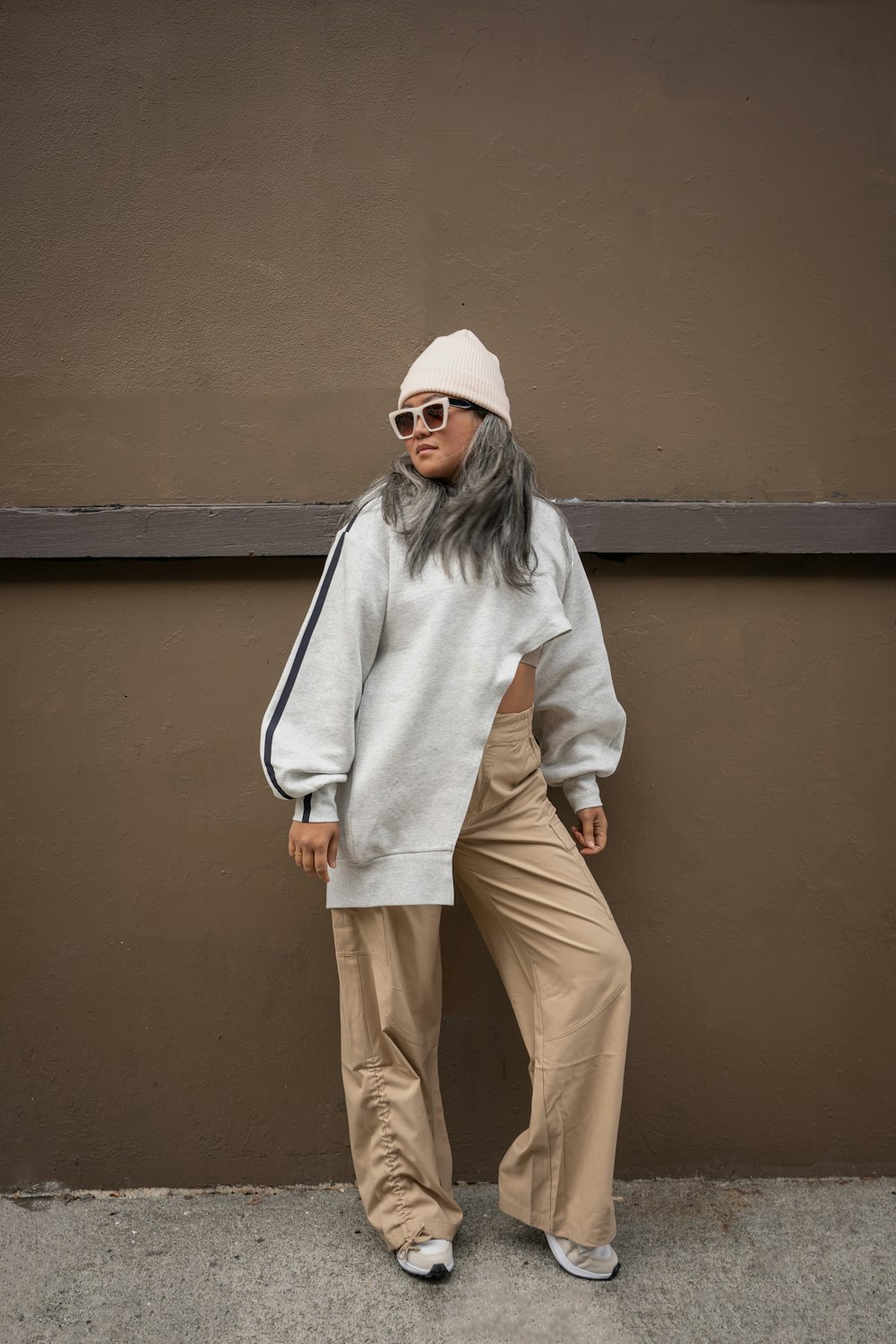 a woman with grey hair wearing a white sweater and khaki pants
