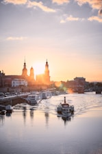 A serene river scene at sunset with traditional boats floating gently on the water.