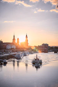A serene river scene at sunset with traditional boats floating gently.