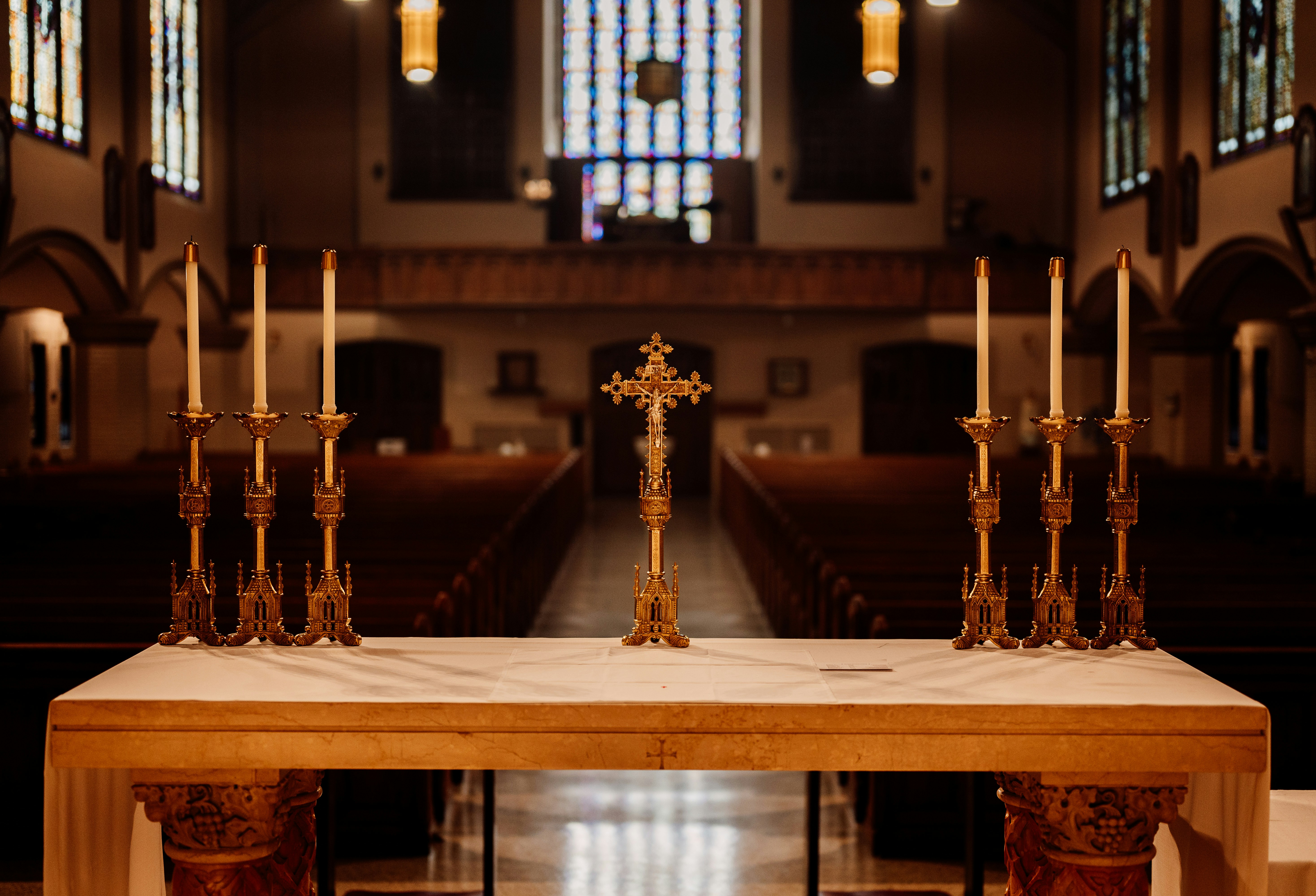 a wooden table topped with candles and a cross