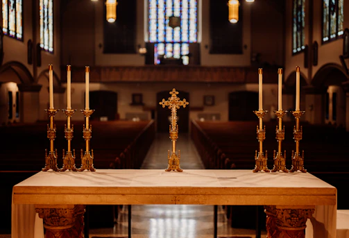 A church altar decorated for Easter with lilies and candles.