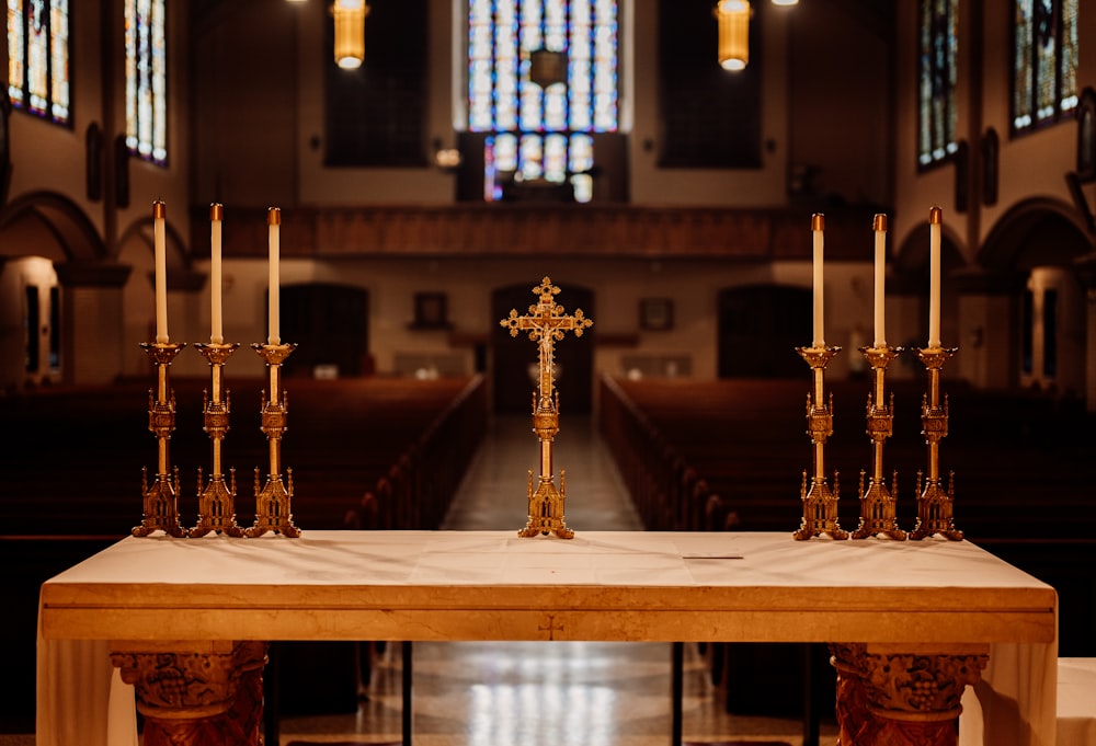 a wooden table topped with candles and a cross