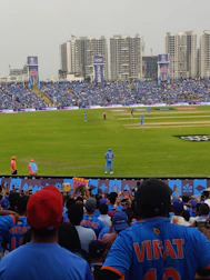 A lively crowd cheering in a packed cricket stadium during an IPL match.