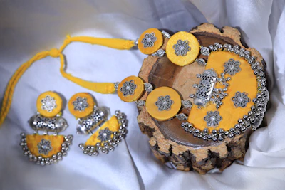 Handcrafted Assamese silk jewellery pieces displayed on a traditional bamboo tray.