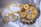 A set of intricately designed jewelry consisting of a necklace and matching earrings, with a vibrant yellow fabric backdrop. The pieces feature ornate silver floral patterns and decorative beads, presented elegantly on a wooden surface.