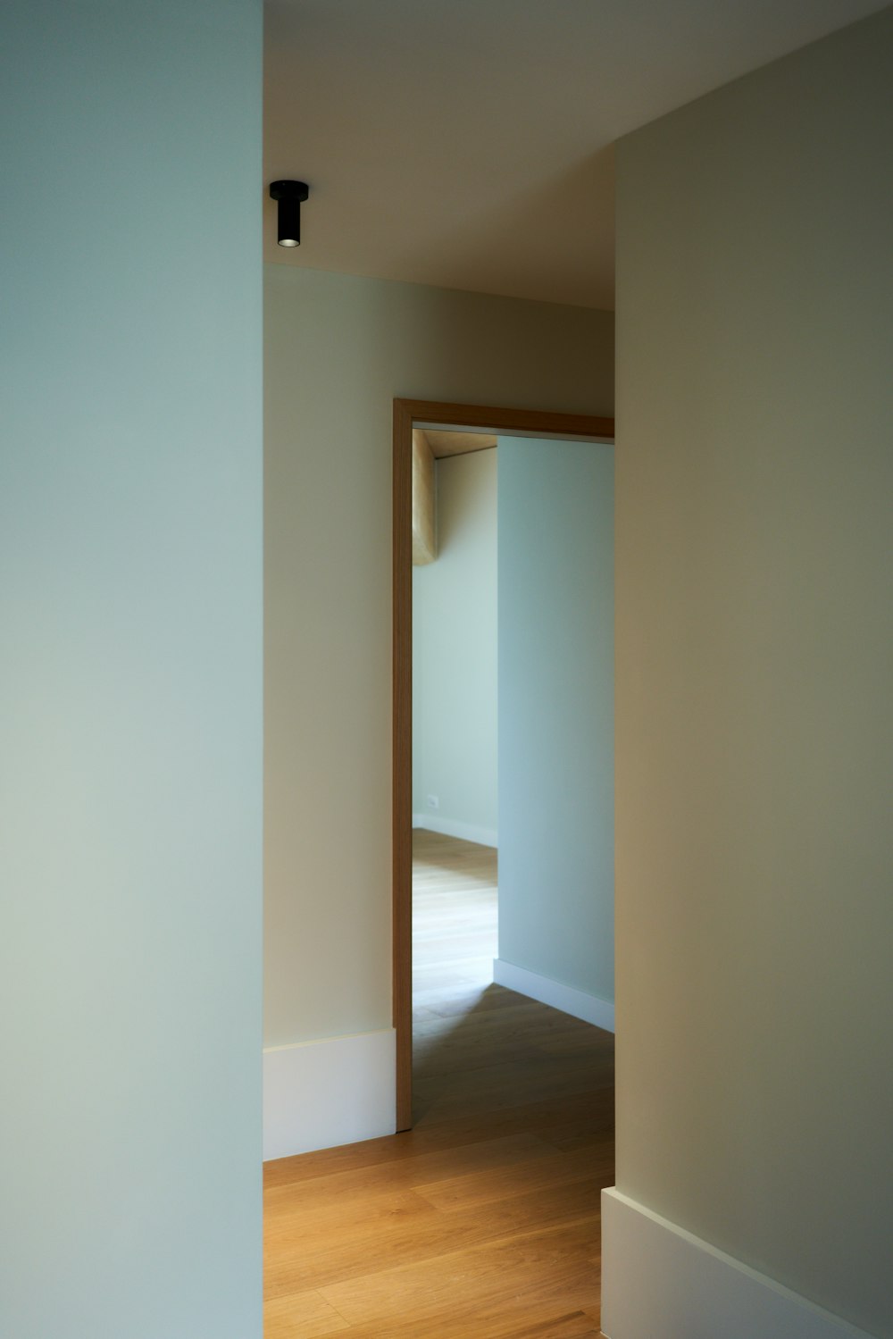 an empty room with hard wood floors and white walls