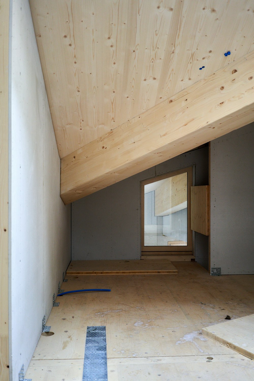 a room with a wooden ceiling and a window