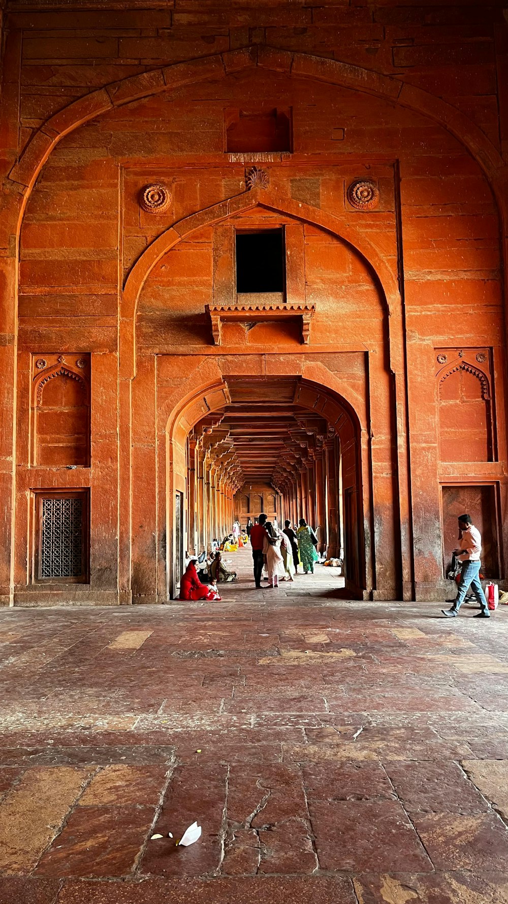 a group of people walking down a long hallway