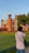 A traveler taking photos of a stunning historical fort against a clear blue sky.