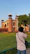 A traveler taking photos of a stunning historical fort against a clear blue sky.