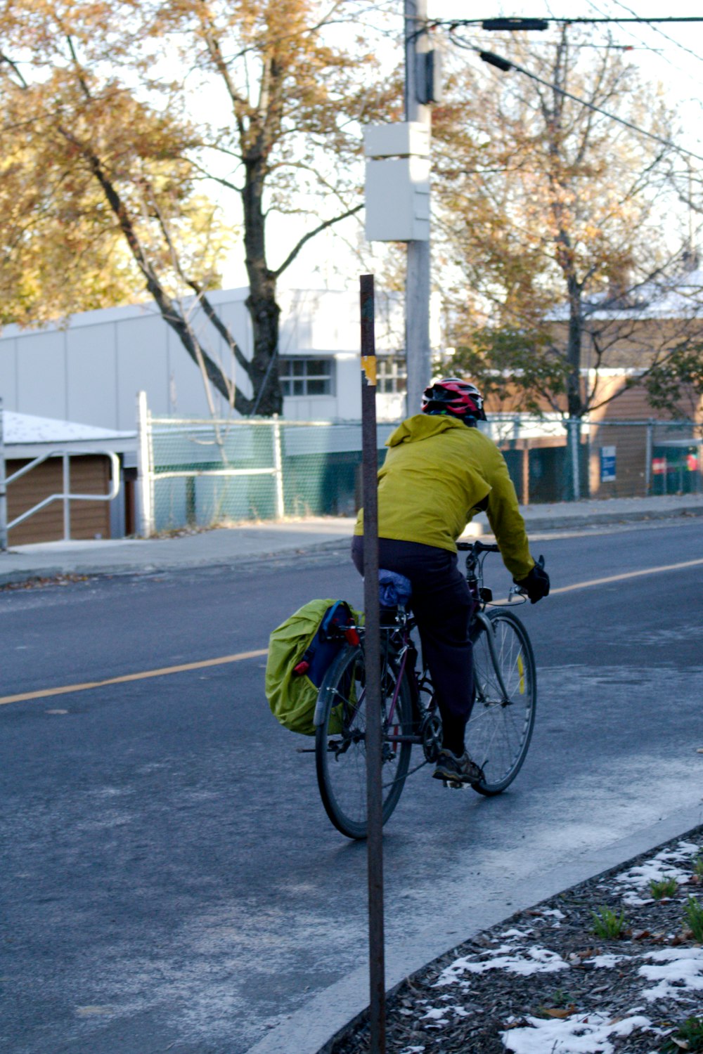 a man riding a bike down a street next to a traffic light