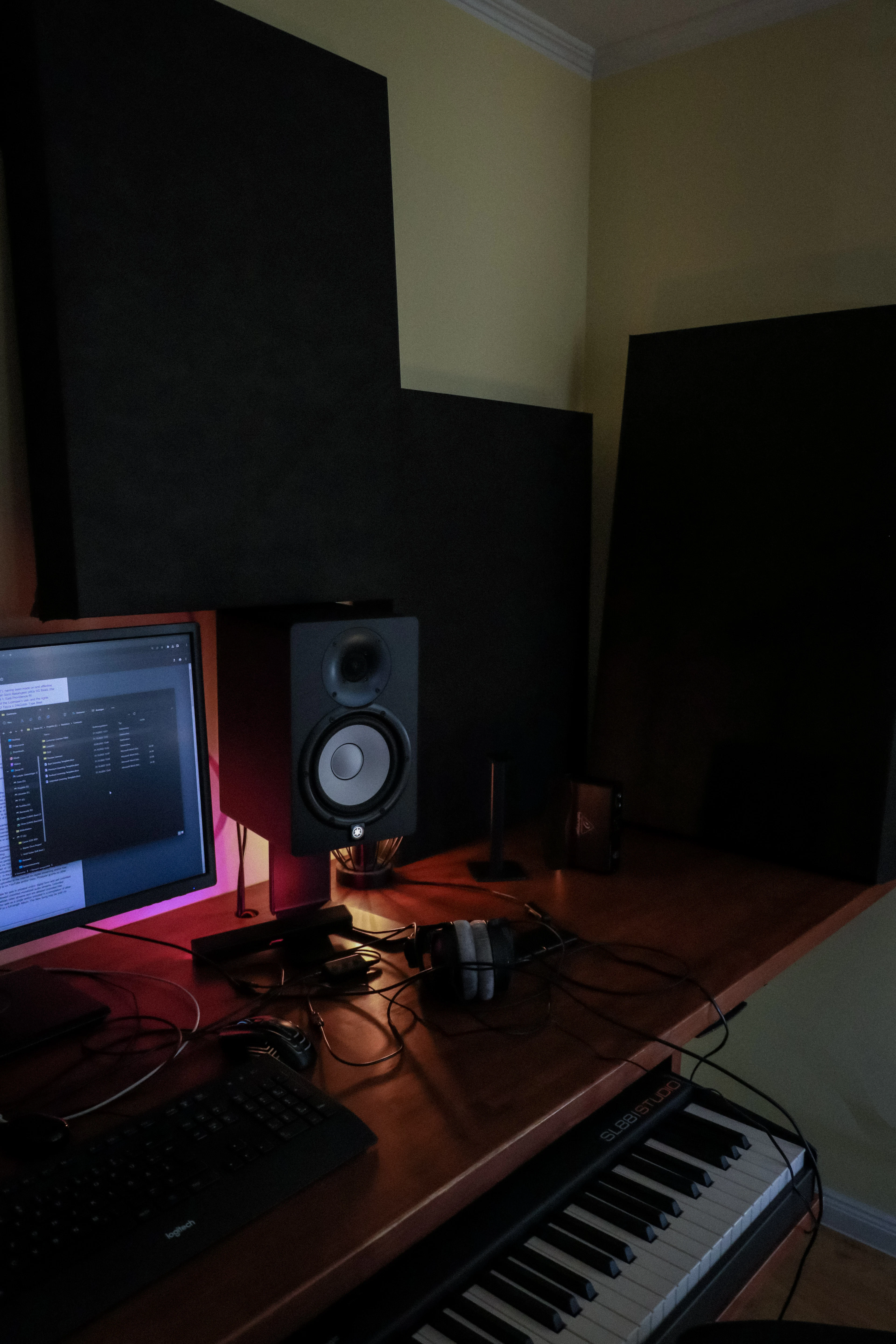 A studio desk with monitor speakers and wall treatment