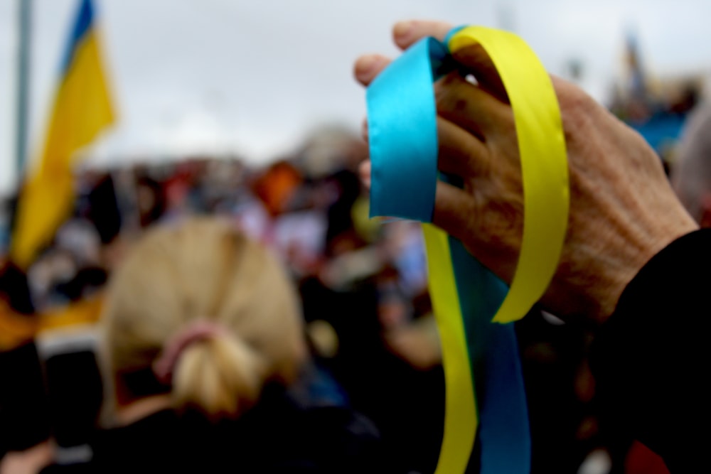 a person holding a ribbon in front of a crowd