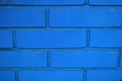 Close-up of hands applying fresh grout between bathroom tiles.