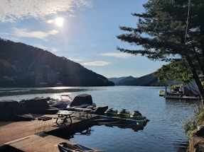 A sunny lakeside scene with a bright jetski docked near a wooden pier reflecting a welcoming, relaxed atmosphere.