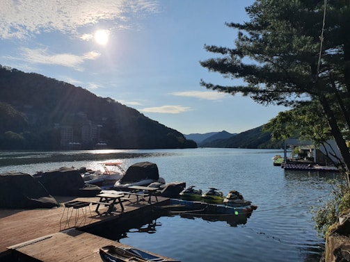 A sunny lakeside scene with a bright jetski docked near a wooden pier reflecting a welcoming, relaxed atmosphere.