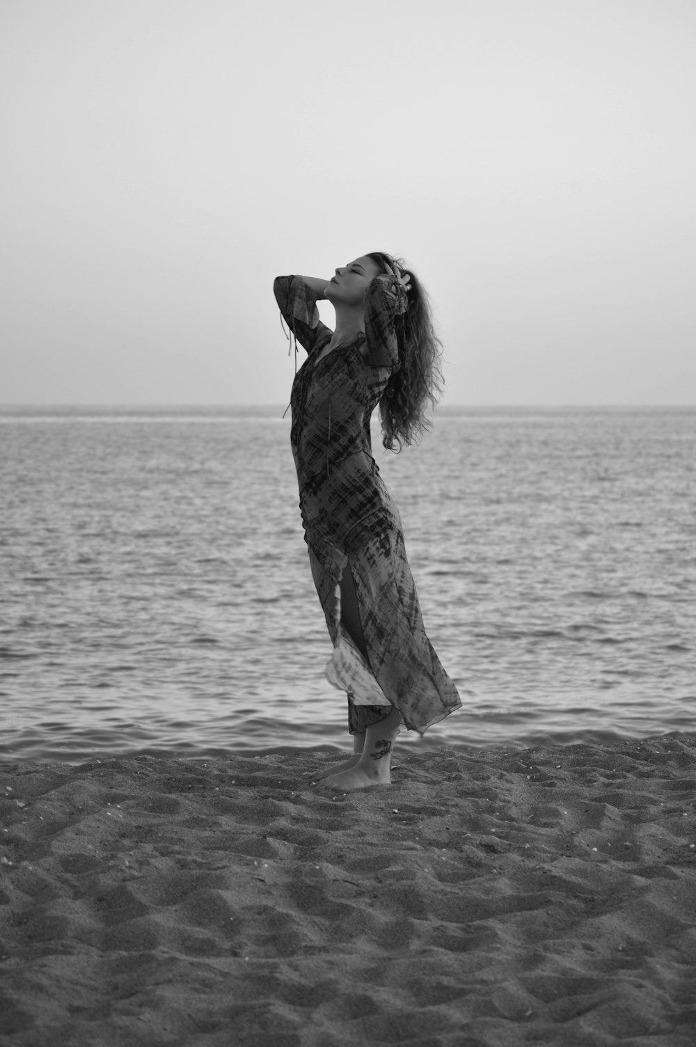 a woman standing on top of a sandy beach