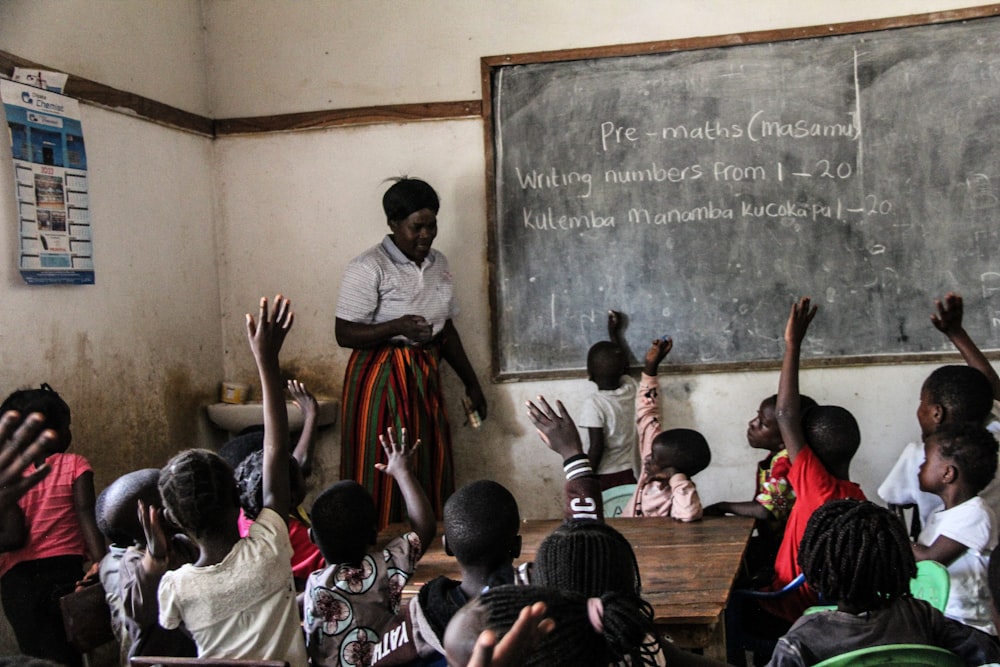 a woman teaching a class of children in a classroom