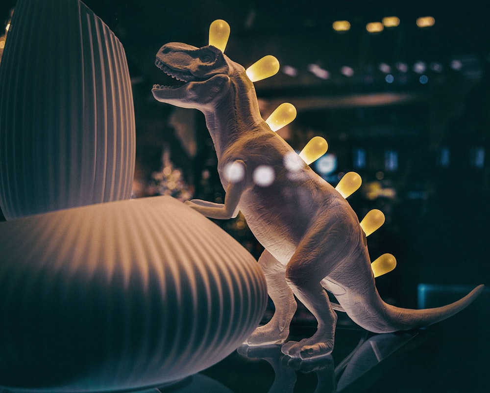 a toy dinosaur standing on top of a table