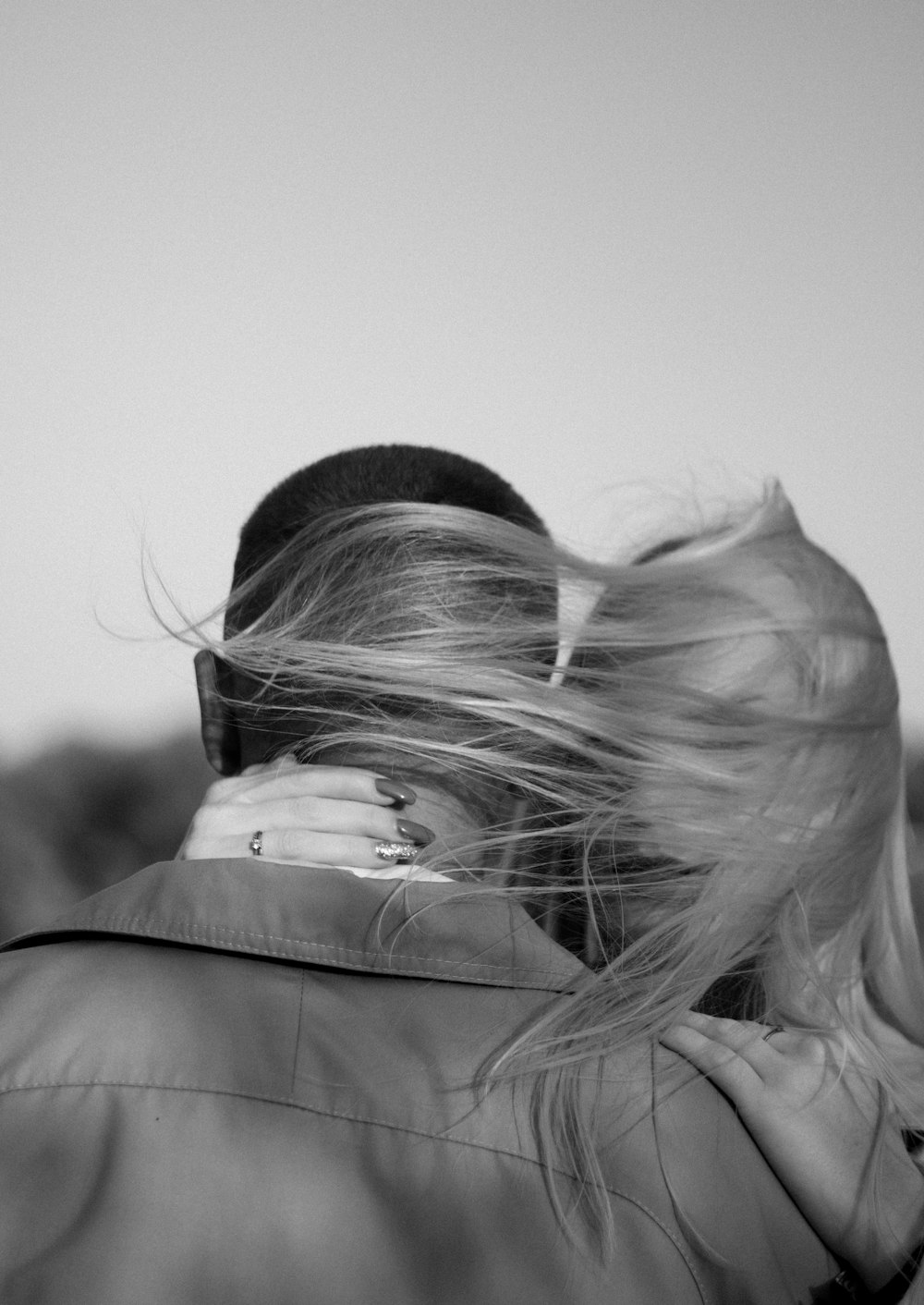 a man and woman embracing each other in a black and white photo