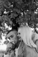 A romantic couple sharing a moment under a blooming tree.