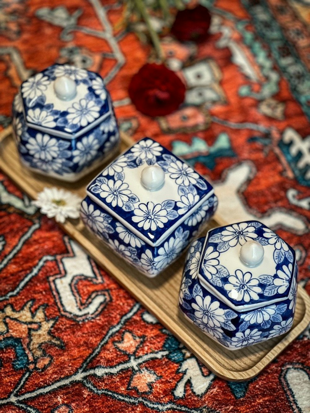 a couple of blue and white candles sitting on top of a wooden tray