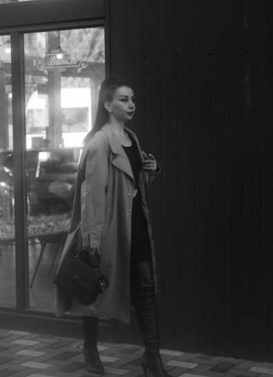 A stylish woman wearing a warm coat walking in an urban setting.