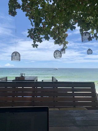 A vibrant Florida beach scene with a laptop open, showing a business website on screen.