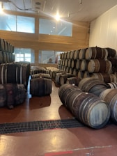 Friendly staff member assisting a customer with barrel options in a bright store setting.