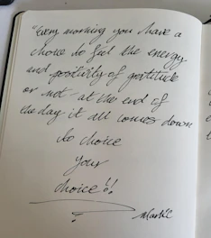 a handwritten note on a notebook with a pen