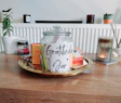 a jar filled with books on top of a wooden table