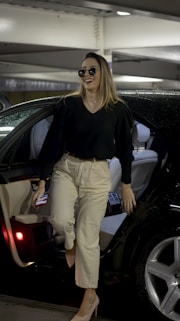 a woman walking out of a car in a parking garage