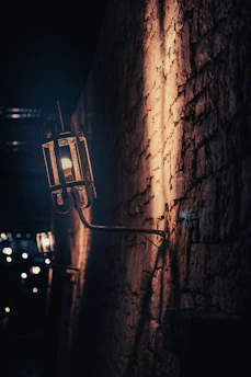 A cozy outdoor wall with metal sconces casting warm light at dusk.