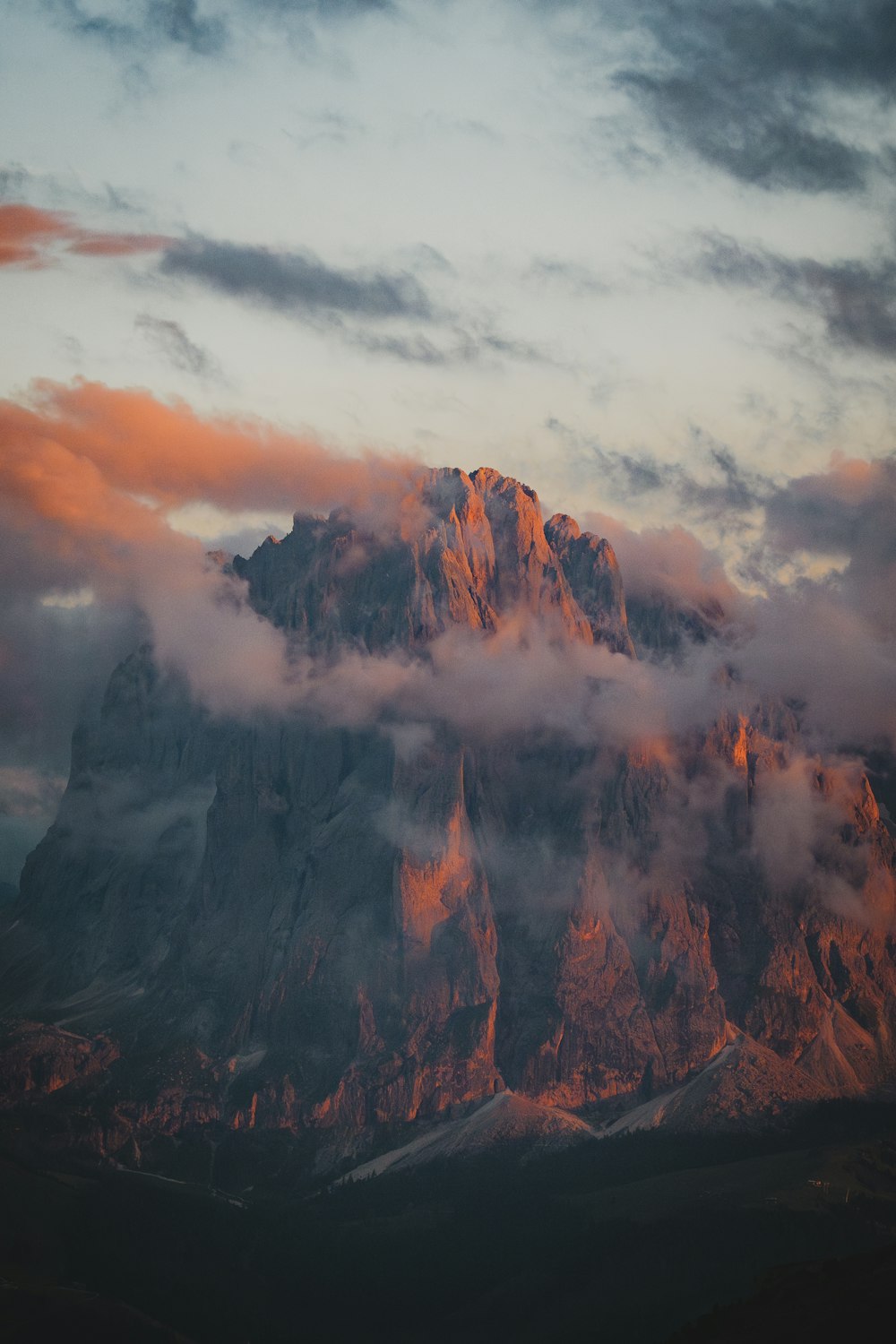 a mountain covered in clouds under a cloudy sky