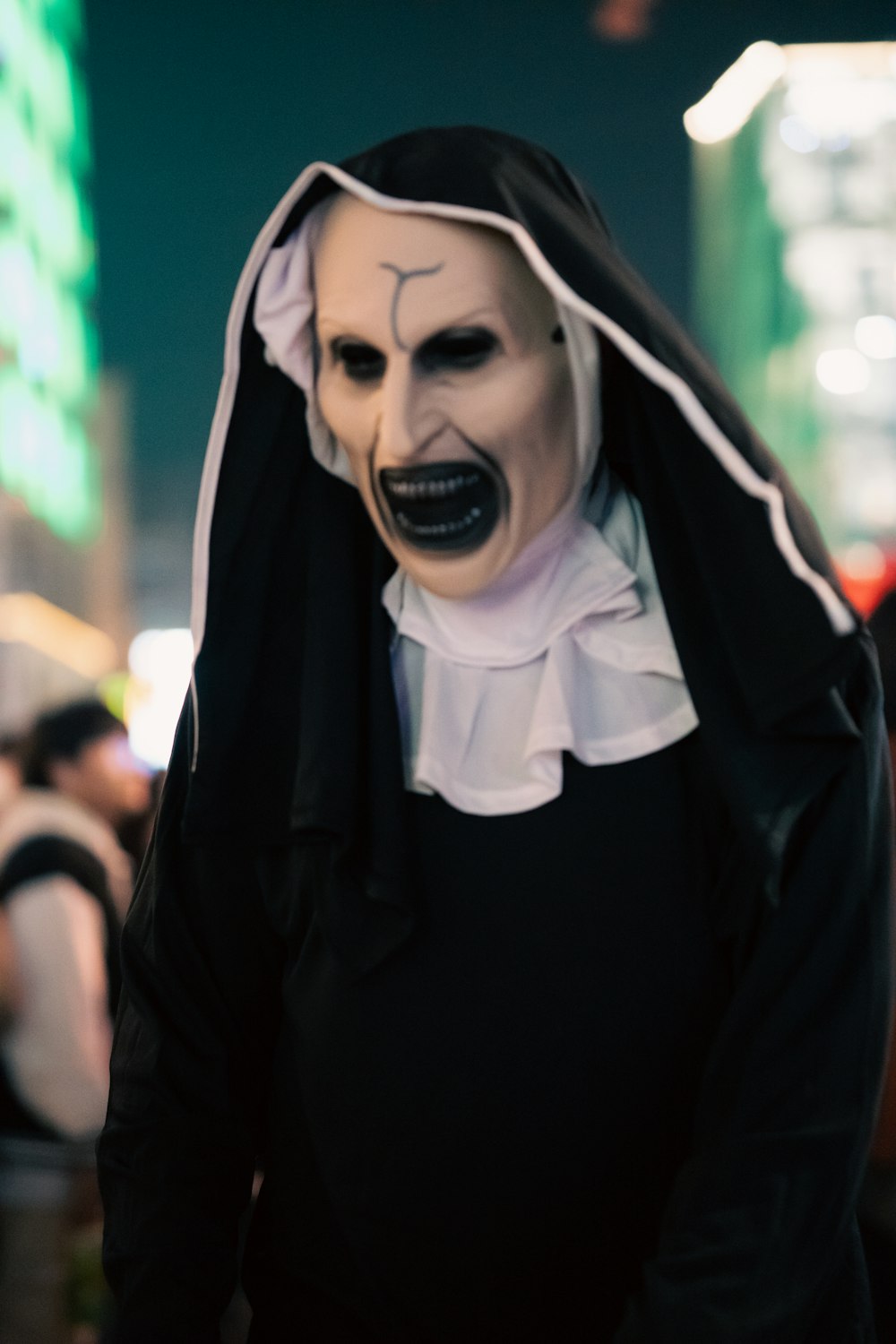 a man wearing a creepy mask and black outfit