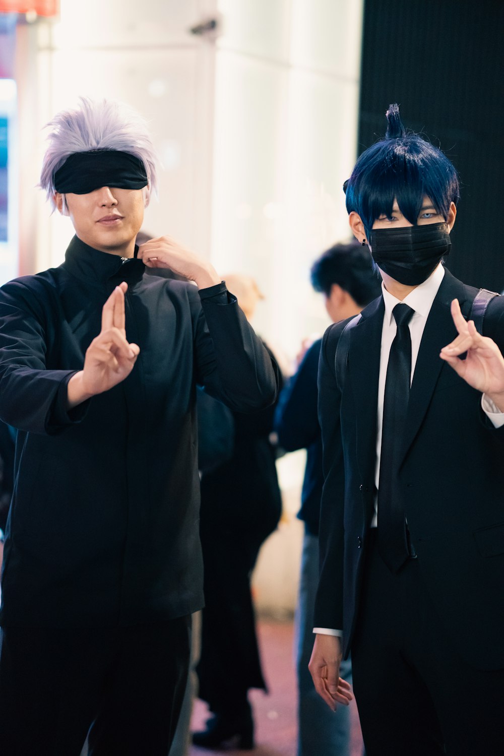 two people wearing blindfolds standing next to each other