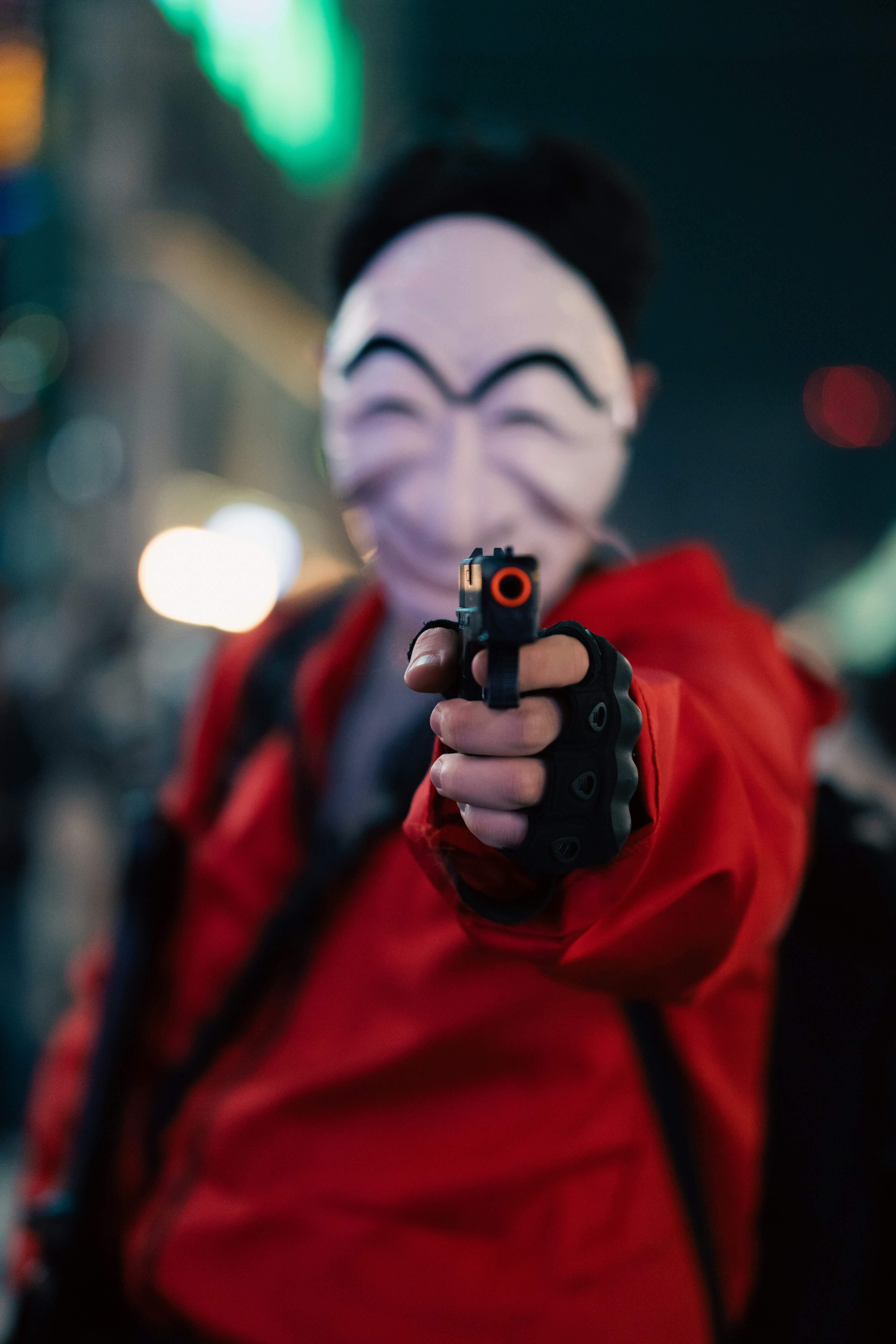 seseorang dengan topeng memegang pistol