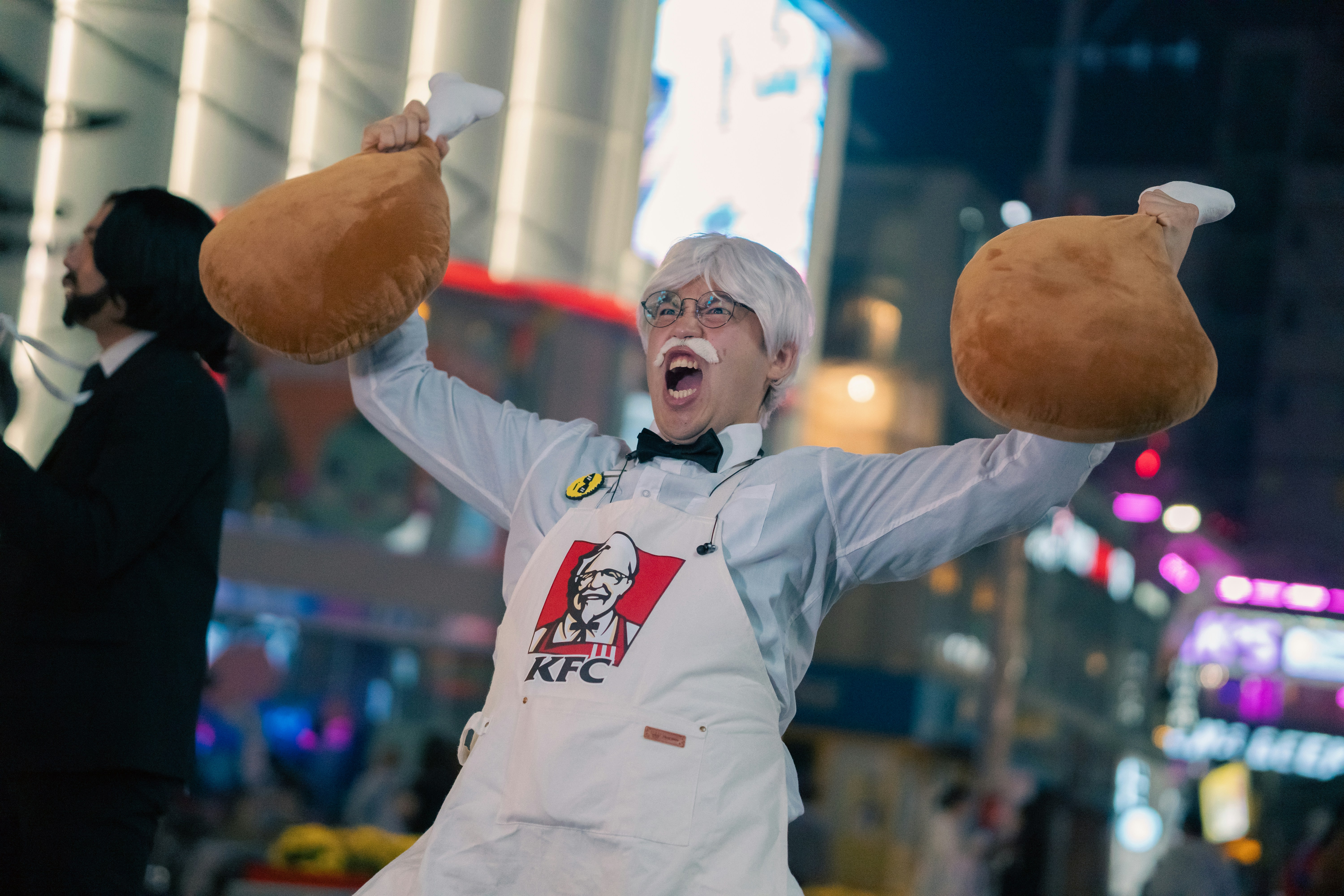 a person in an apron holding two hot dogs