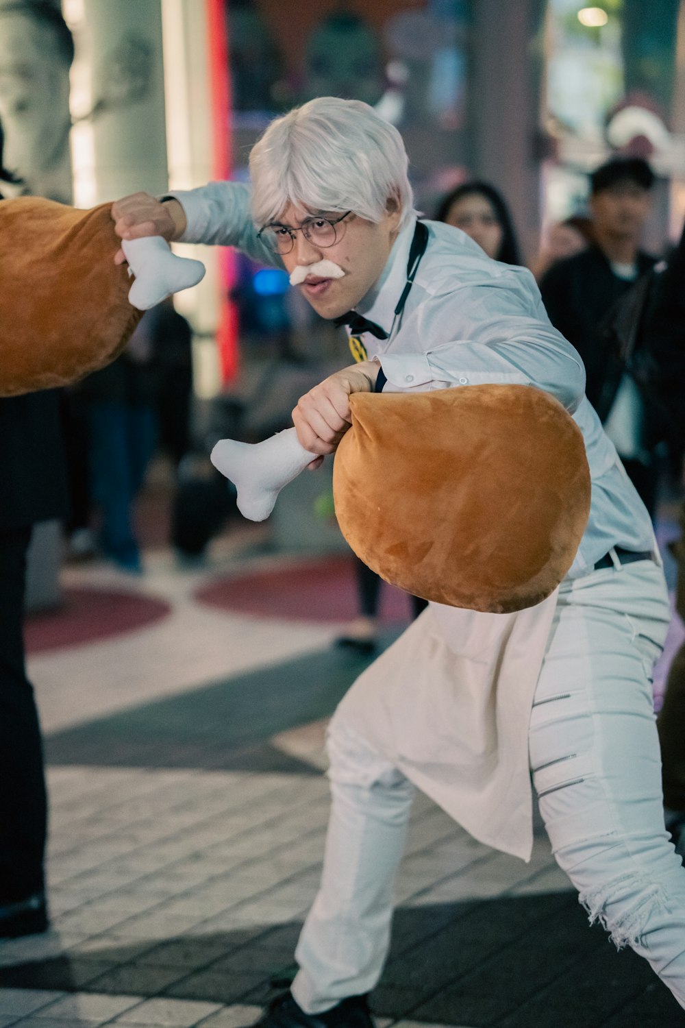 a man in a costume is holding a stuffed animal