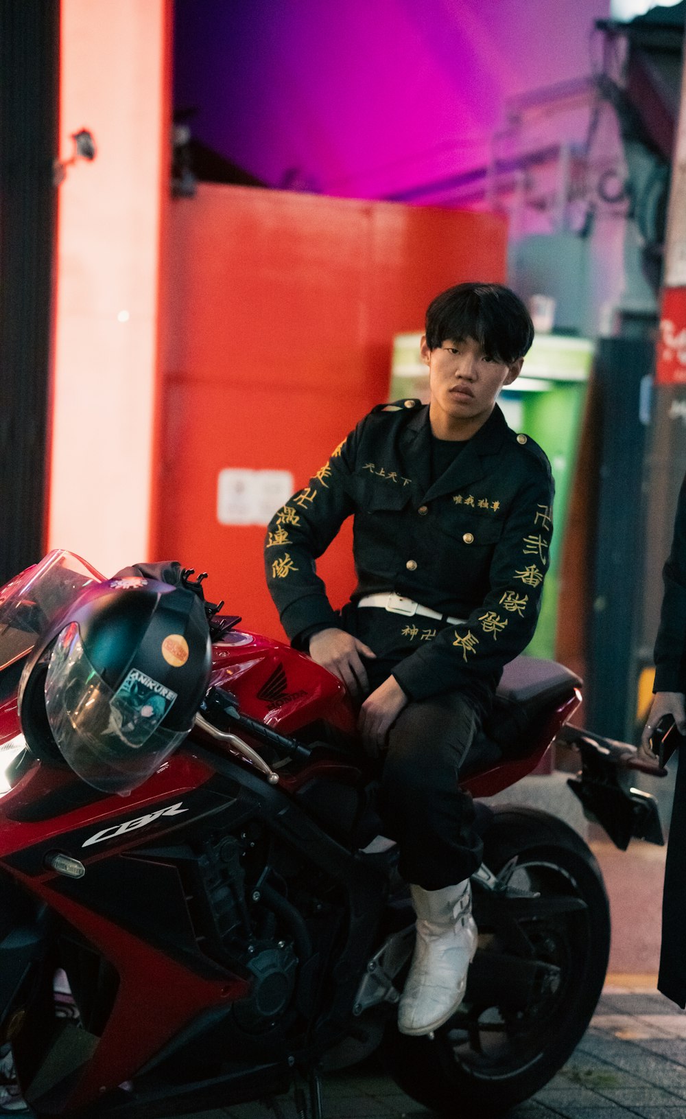 a man sitting on top of a red motorcycle