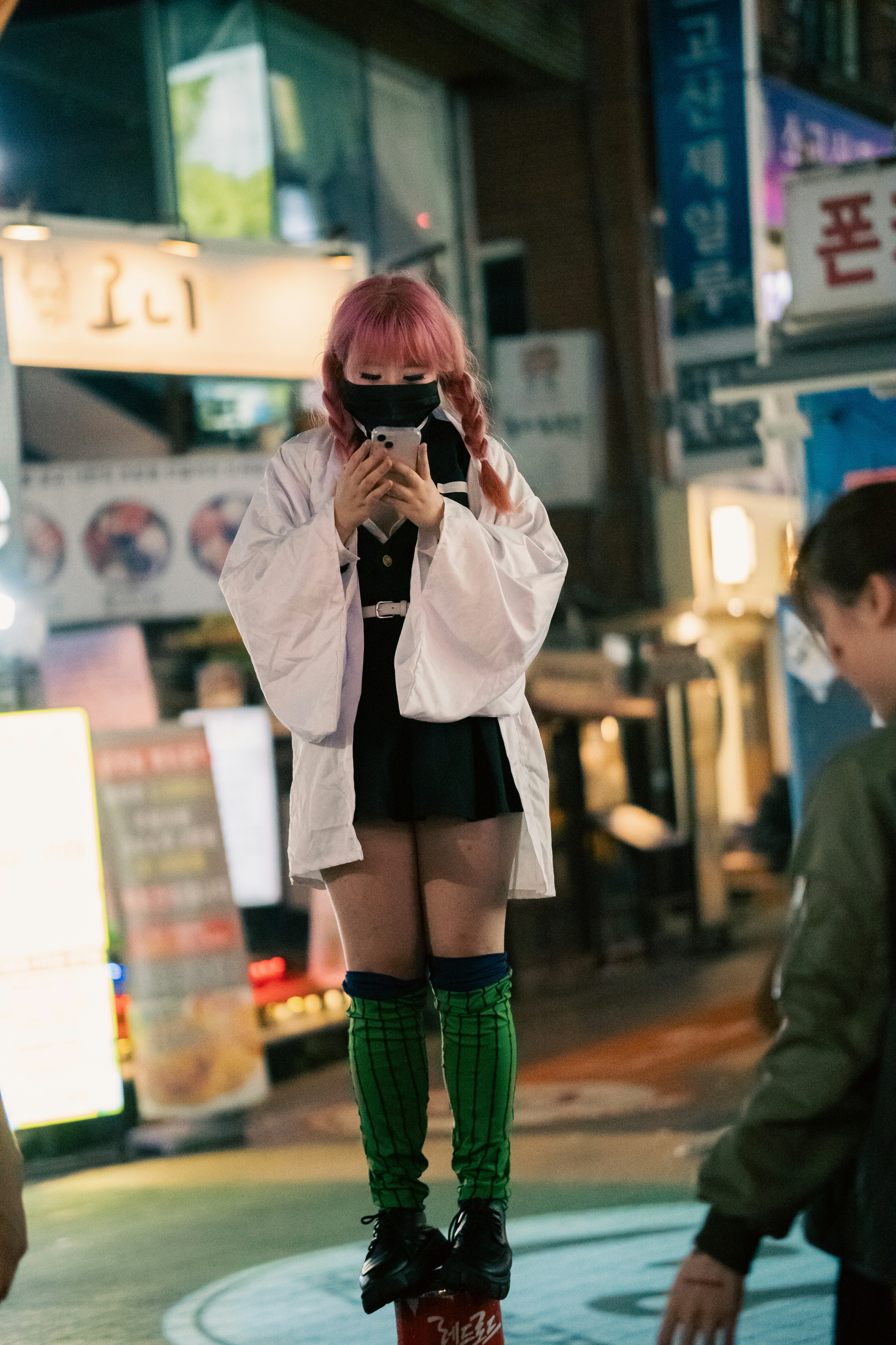 Seorang wanita dengan celana pendek pendek dan sepatu bot setinggi lutut mengambil gambar
