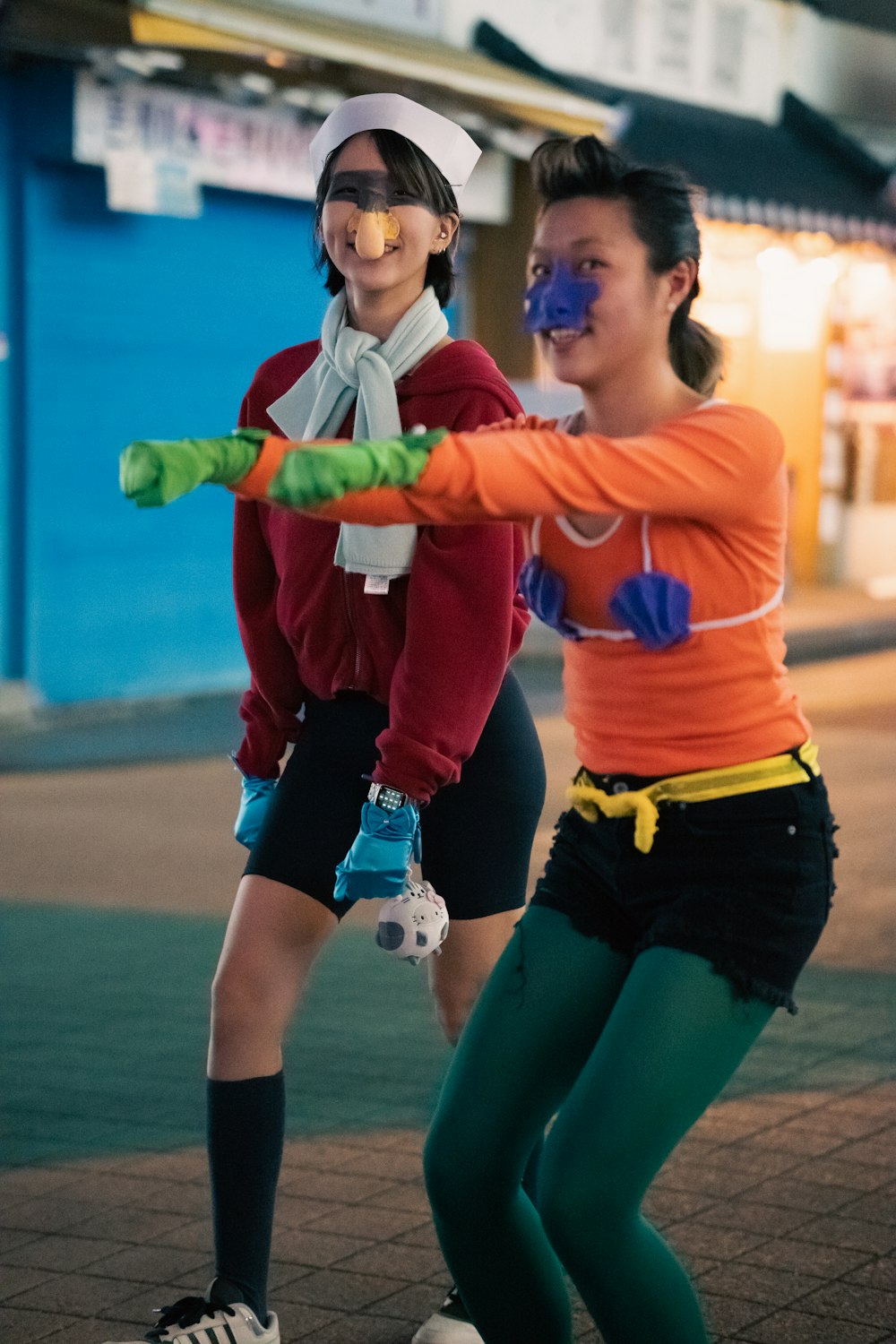 two women in costumes are playing with a toy