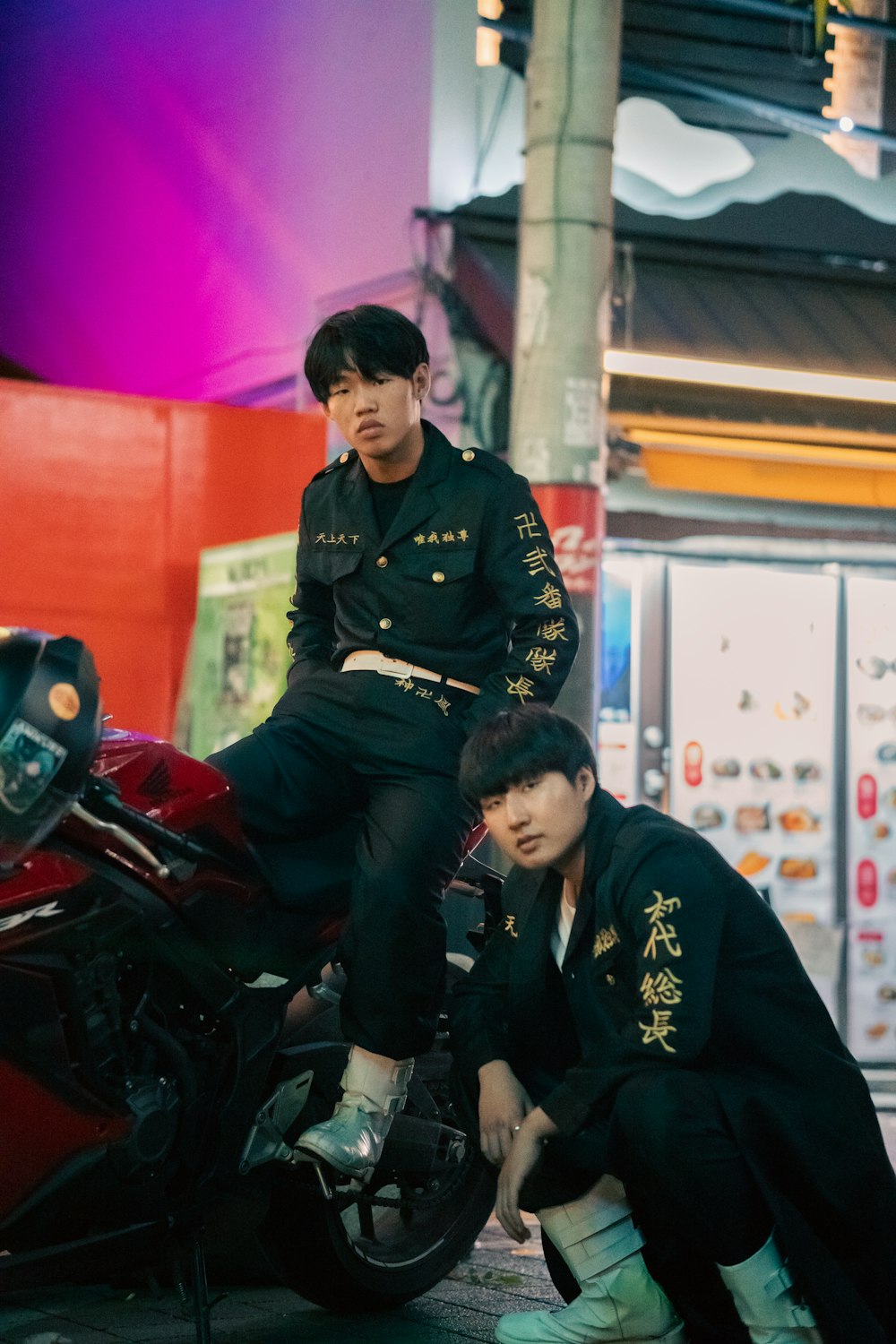 two men sitting on the back of a motorcycle