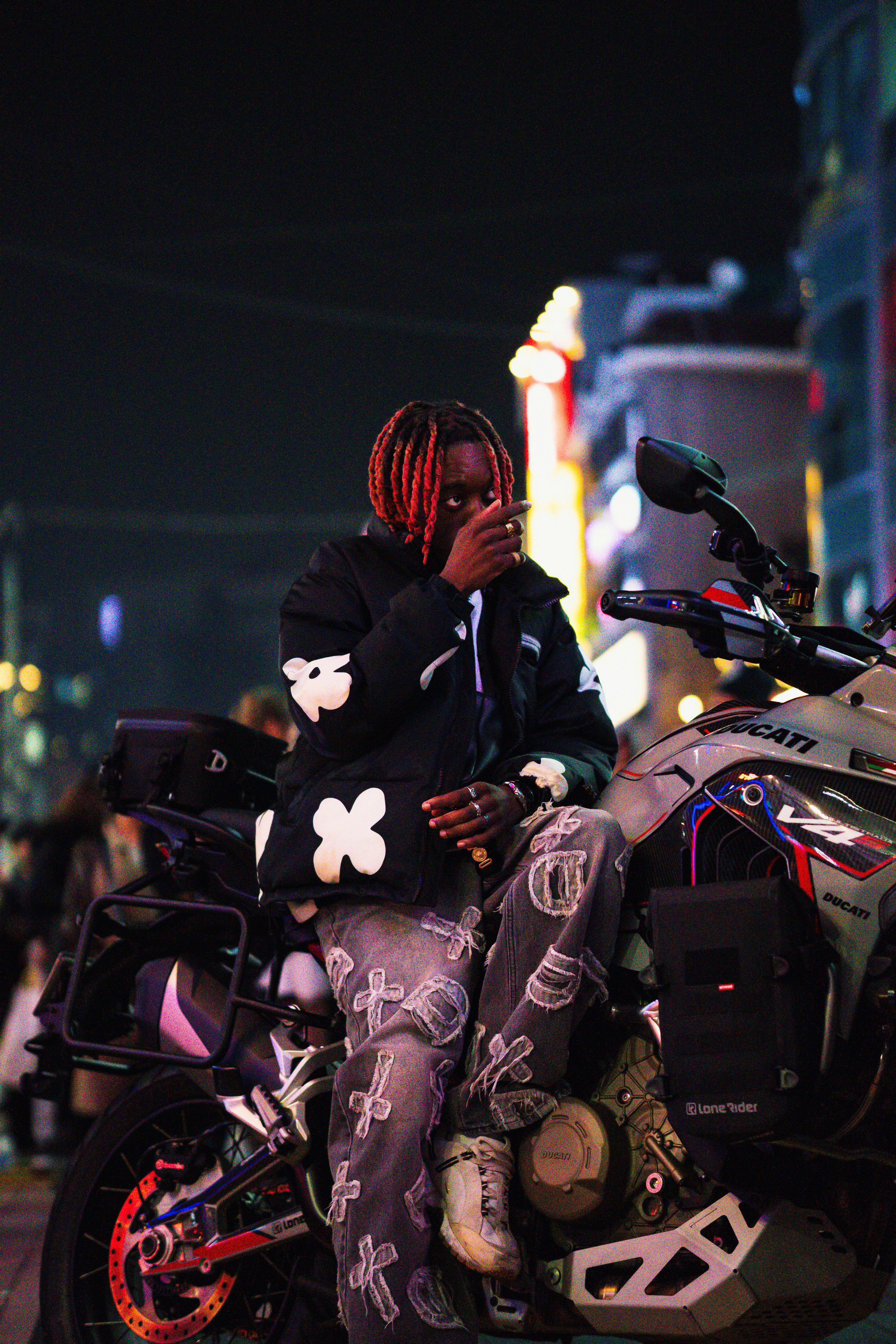 a man with dreadlocks sitting on a motorcycle
