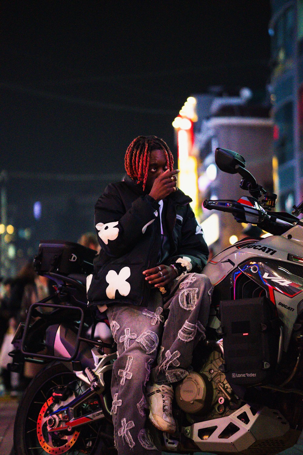a man with dreadlocks sitting on a motorcycle