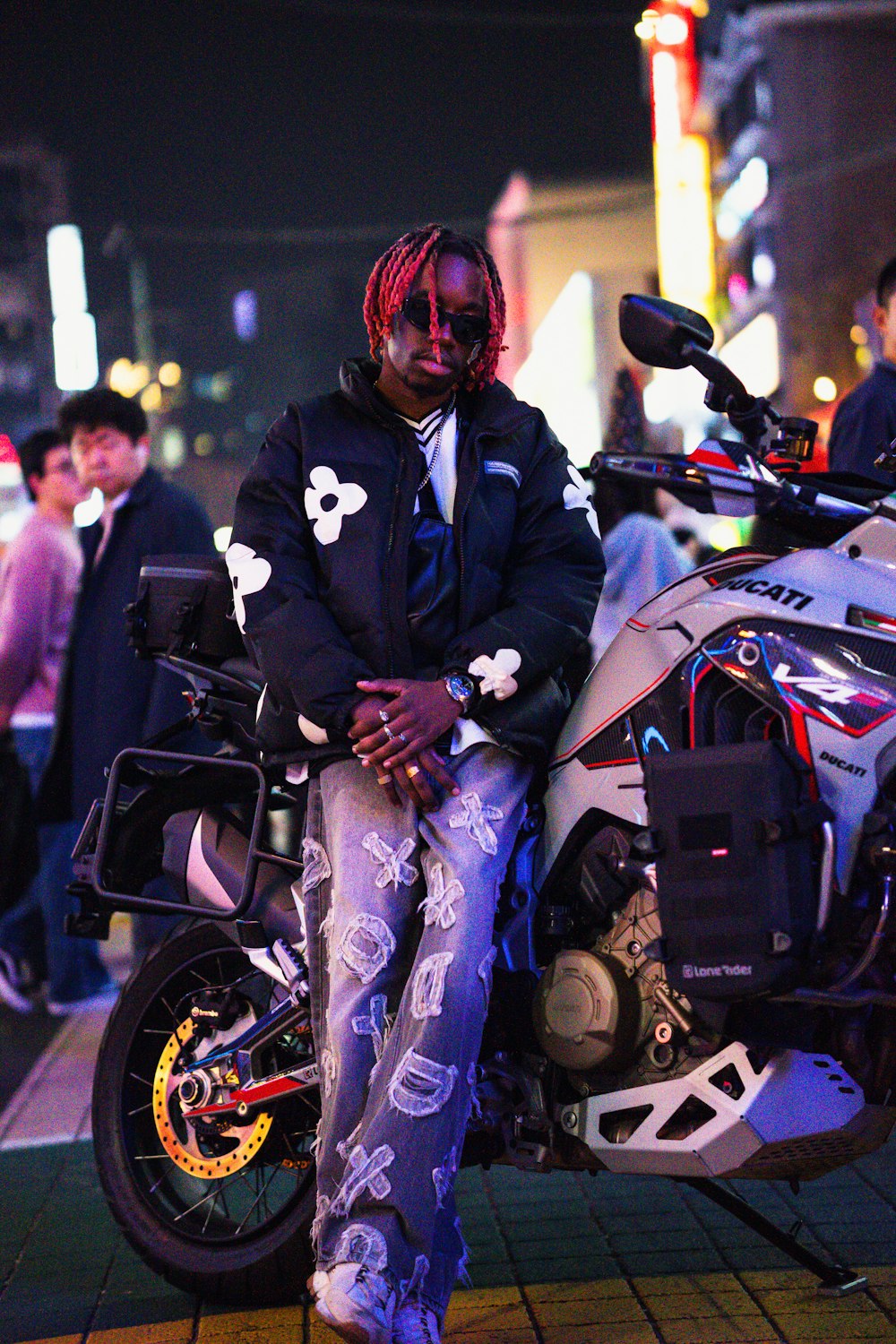 a man sitting on a motorcycle on a city street