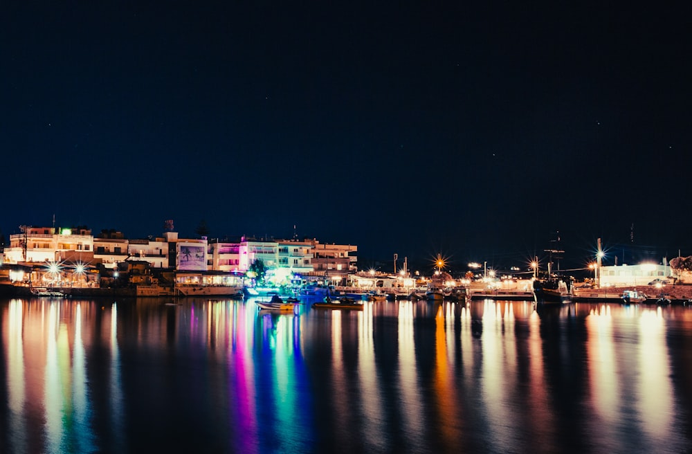 Una vista nocturna de una ciudad con luces que se reflejan en el agua